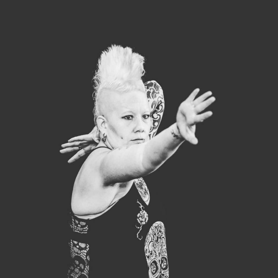 Black and white photo of a dancer with arm outstretched in front of them